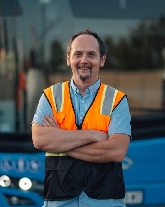 Busfahrer mit Warnweste vor seinem Fahrzeug