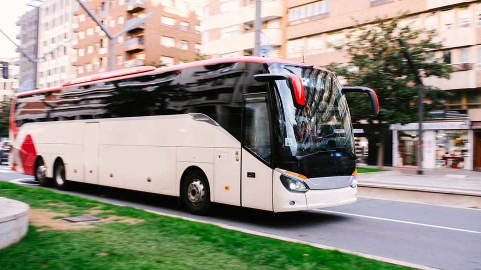Moderner Reisebus unterwegs auf einer Stadtstraße