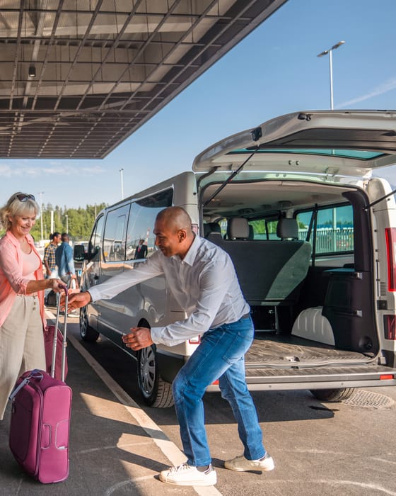 Busfahrer verlädt das Gepäck einer Reisegruppe