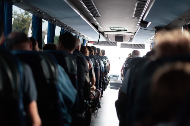 Fahrgäste sitzen während einer Gruppenfahrt im Reisebus