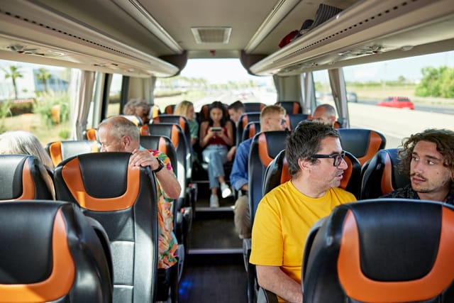 Fahrgäste sitzen während einer Gruppenfahrt im Reisebus
