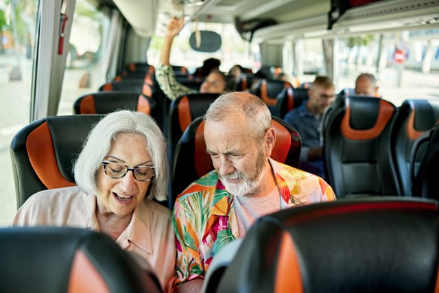 Älteres Paar sitzt nebeneinander im Reisebus