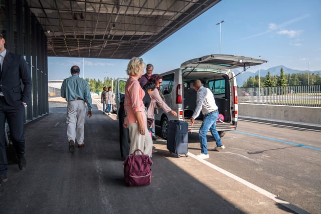 Reisegruppe wartet mit Gepäck auf den bestellten Bus